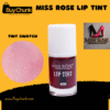 Miss Rose Lip Tint bottle in clear glass with white cap, showcasing its vibrant reddish-pink color. A tint swatch on skin demonstrates the natural flush, alongside the Miss Rose Professional Make-Up logo