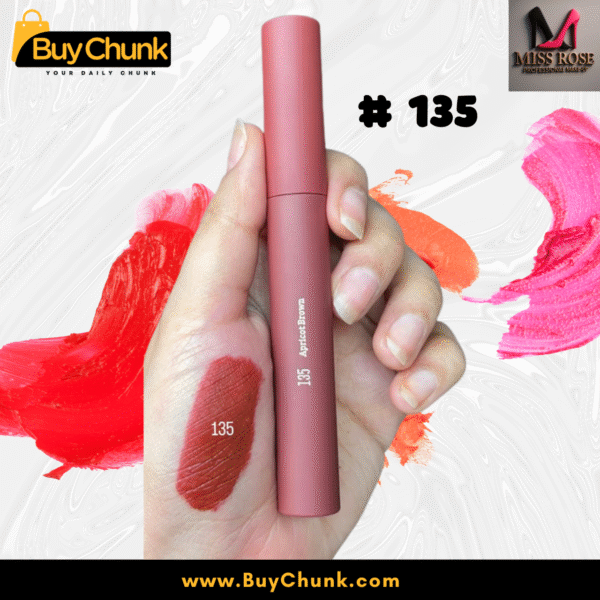 A close-up of a hand swatched with Miss Rose Matte Lip Gloss Shade 135, showing the rich rosy-red color, with the lip gloss tube being held.
