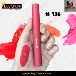 A close-up of a hand swatched with Miss Rose Matte Lip Gloss Shade 136, showing the rich rosy-red color, with the lip gloss tube being held.