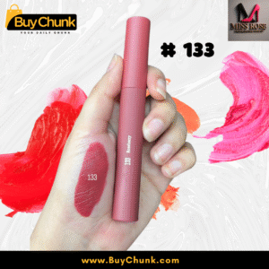 A close-up of a hand swatched with Miss Rose Matte Lip Gloss Shade 133, showing the rich rosy-red color, with the lip gloss tube being held.