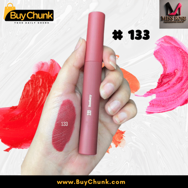 A close-up of a hand swatched with Miss Rose Matte Lip Gloss Shade 133, showing the rich rosy-red color, with the lip gloss tube being held.
