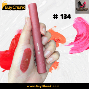 A close-up of a hand swatched with Miss Rose Matte Lip Gloss Shade 134, showing the rich rosy-red color, with the lip gloss tube being held.