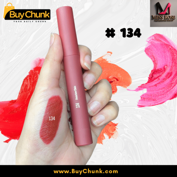 A close-up of a hand swatched with Miss Rose Matte Lip Gloss Shade 134, showing the rich rosy-red color, with the lip gloss tube being held.